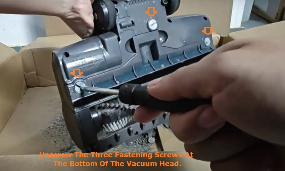 unscrew the three fastening screws at the bottom of the vacuum head