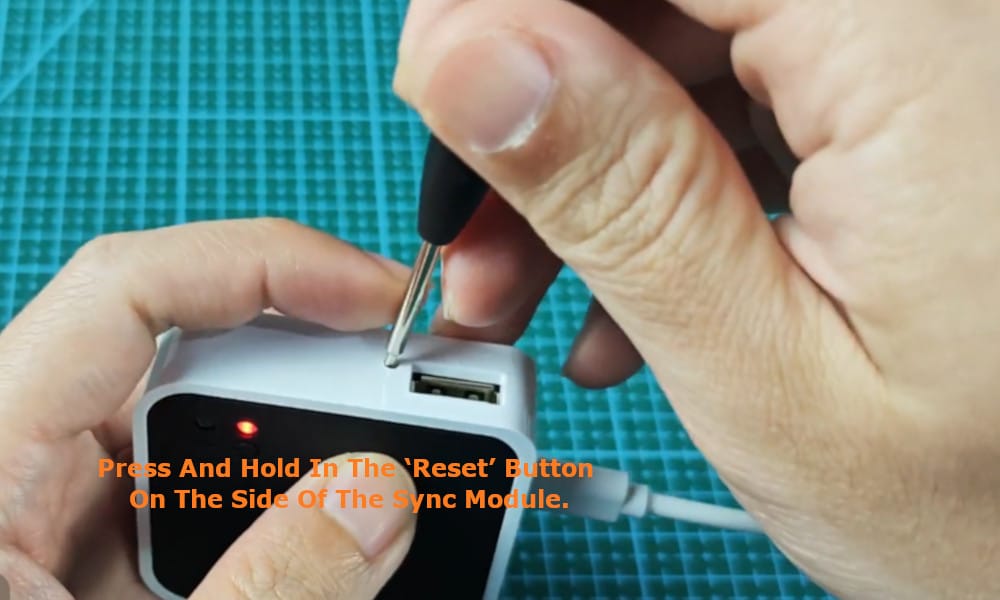press and hold in the ‘reset’ button on the side of the Sync Module